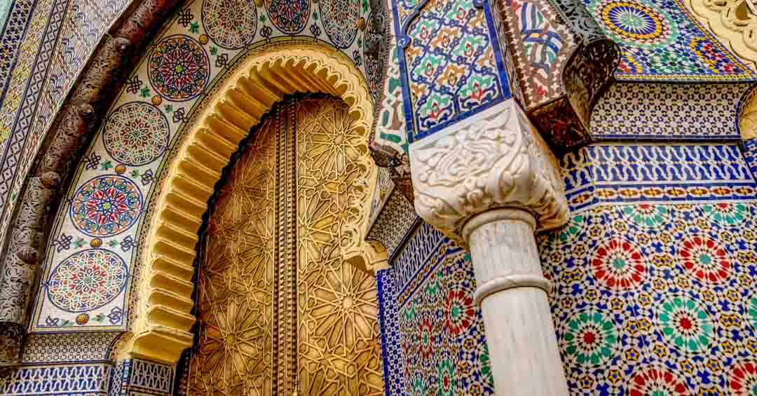 Intricate tiles in blue,yellow,red colors and metal work on Fes building. 